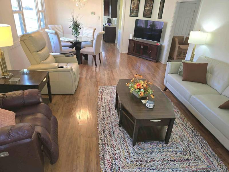 Occupied rental living room full of the tenant's furniture, then the same room emptied by Unstager — before
